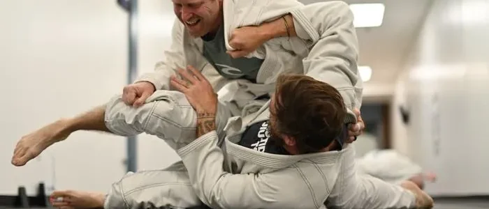 Two adults training gi jiu jitsu on the mats at High Tide Jiu Jitsu in Sea Girt, New Jersey